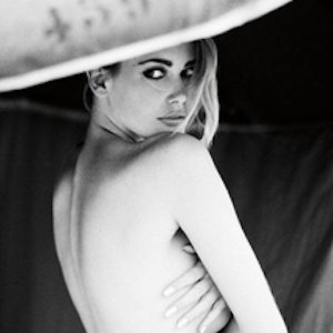 Parasol, Deauville, 1990 by Ellen von Unwerth, portrait of nude model hugging herself