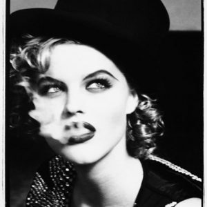 Eva Herzigova, the tramp by Ellen von Unwerth, portrait of the model in a rhinestone vest and tophat, smoking