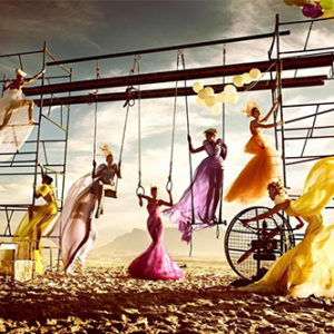 Strand II by Kristian Schuller, models in colorful flowy dresses on a climbing frame at the beach