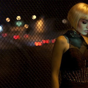 Rising from a dream, 2012 by Guido Argentini, model in blonde wig standing in front of a fence next to a street