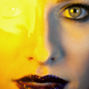 Sydney's Yellow Eyes by Guido Argentini, Closeup portrait of a model in a red glitter lip, yellow light erasing one of her eyes