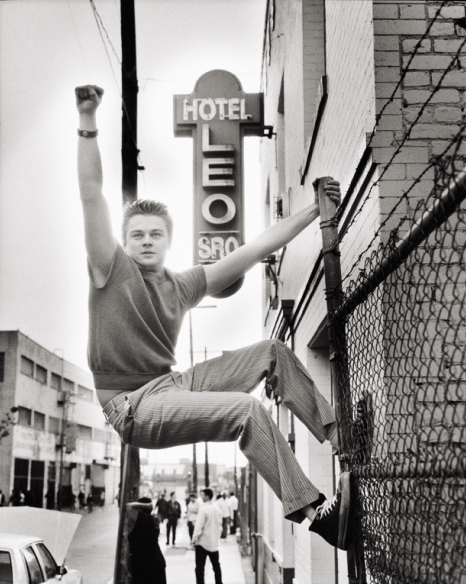 Leonardo Di Caprio, Los Angeles Leonardo Di Caprio, Los Angeles by Mark Seliger, tha actor climbing a fence in front of a hotel sign