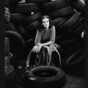 Julia Roberts by Timothy White, the actress sitting inbetween a pile of old tires