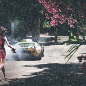 Wheels and heels diamond dust by David Drebin, model in pink dress running a fter a car