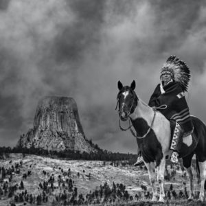 Chief by David Yarrow, Native Chieve with feather headpiece sitting on pinto horse
