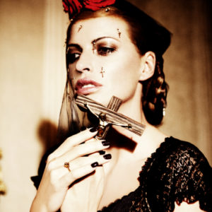 Prayer, from the story of olga by Ellen von Unwerth, model in veil with red roses and cruzifix