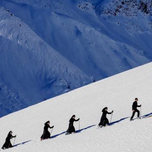 Saint Moritz St. Moritz Switzerland 2024 by Tony Kelly, a group of Nuns hiking up a snowy mountain with ski